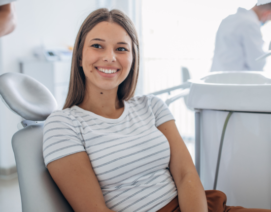 Adolescente feliz en la consulta del dentista